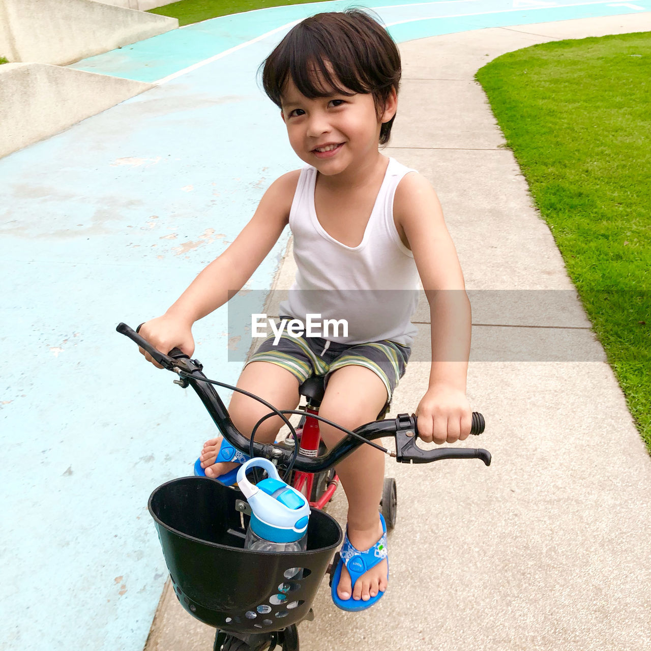 Portrait of cute boy riding bicycle outdoors