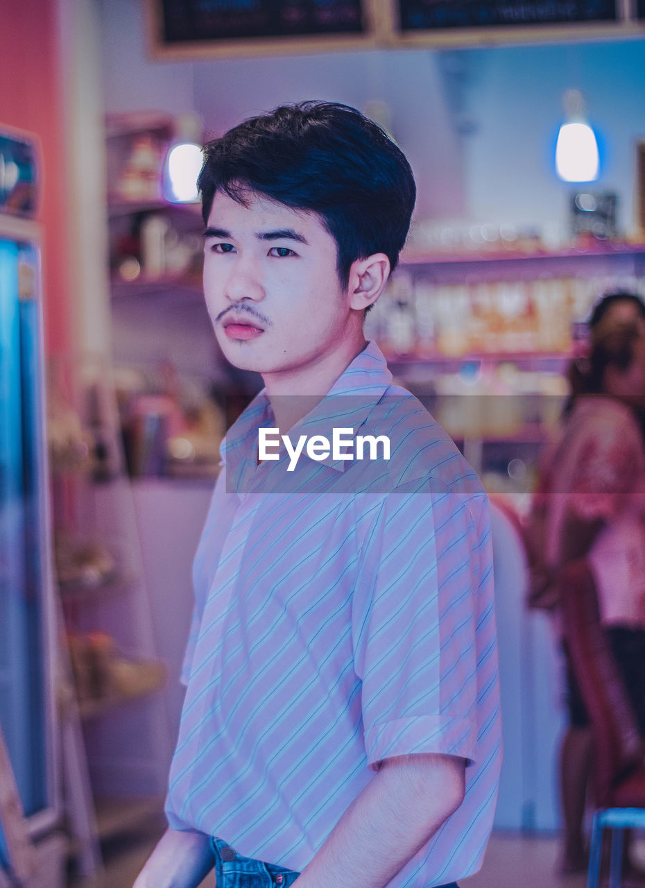 Thoughtful young man standing in store