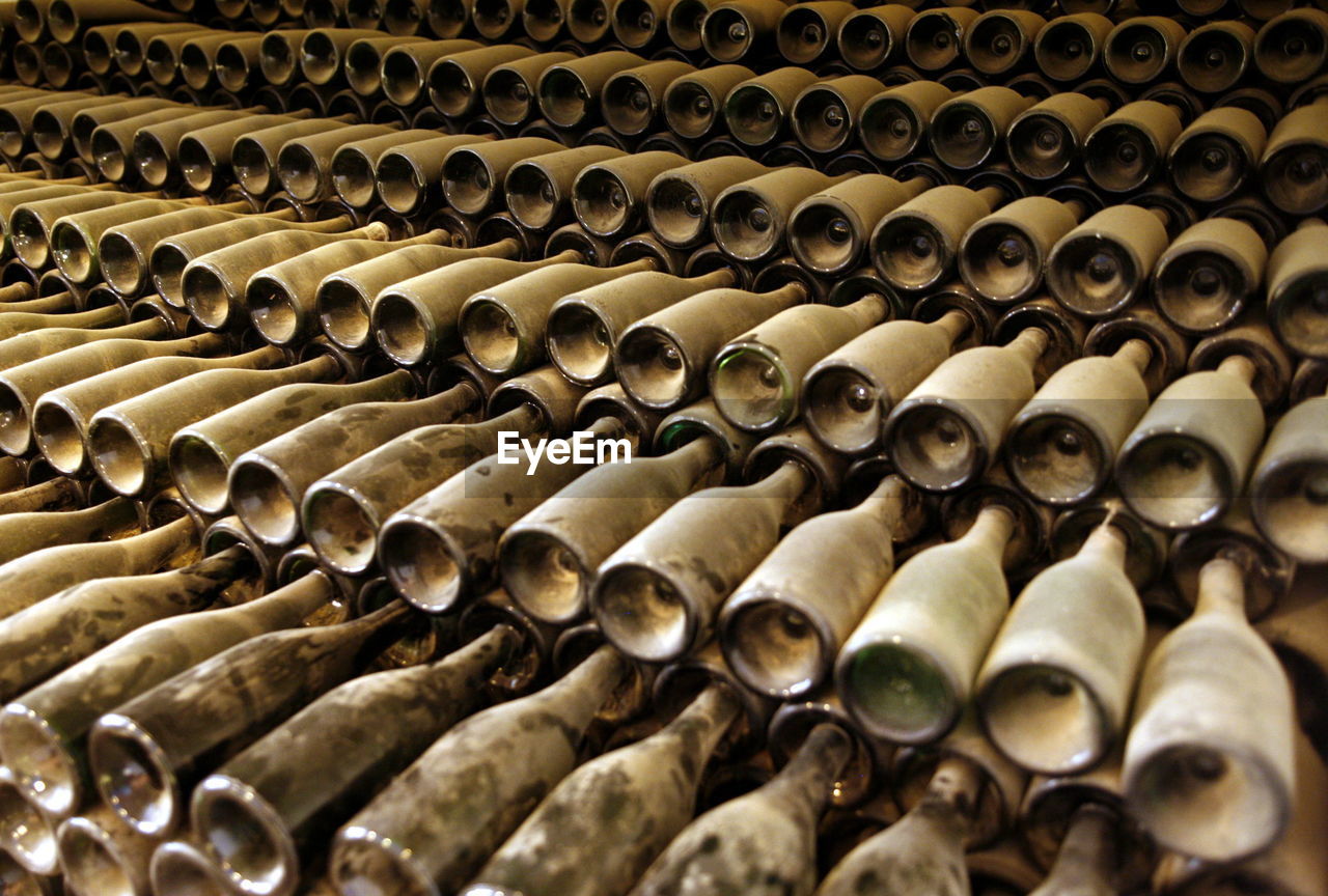 Full frame shot of dust covered wine bottles in warehouse