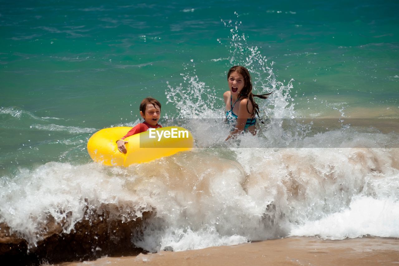 Siblings enjoying in sea