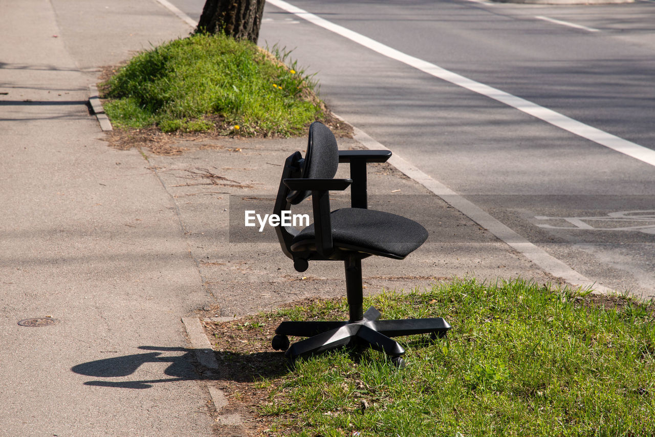 EMPTY BENCH ON ROAD BY FOOTPATH