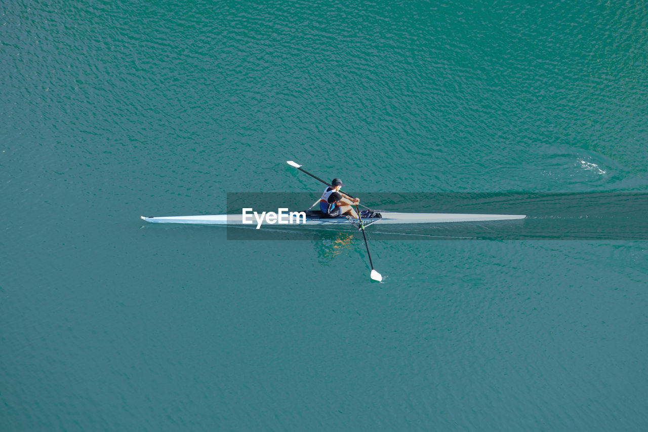 water, nautical vessel, transportation, mode of transportation, oar, sports, rowing, nature, high angle view, vehicle, day, sea, men, lifestyles, adult, leisure activity, water sports, beauty in nature, outdoors, adventure, wing, one person, travel, motion, waterfront, aerial view, boat, blue, boating, tranquility, recreation, copy space, kayak