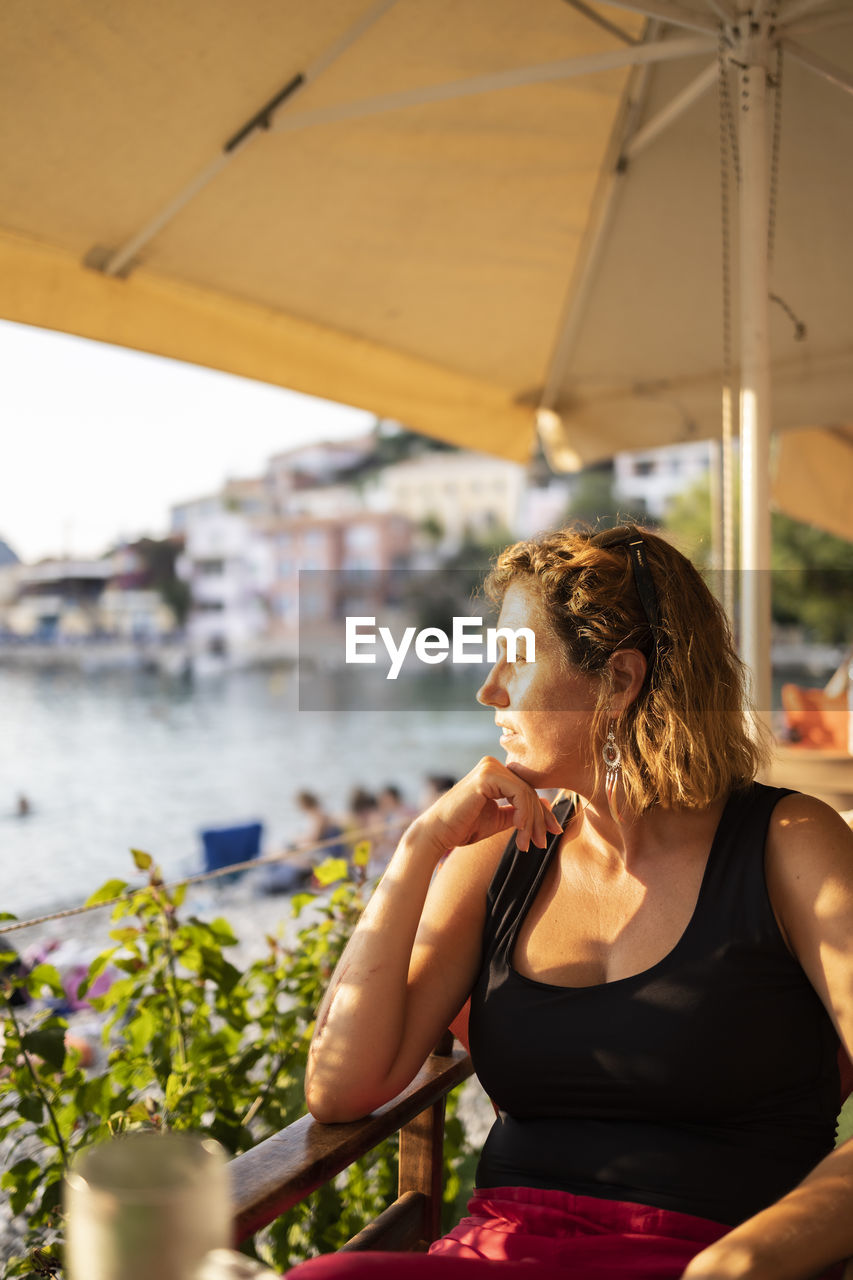 Woman looking away while sitting in water