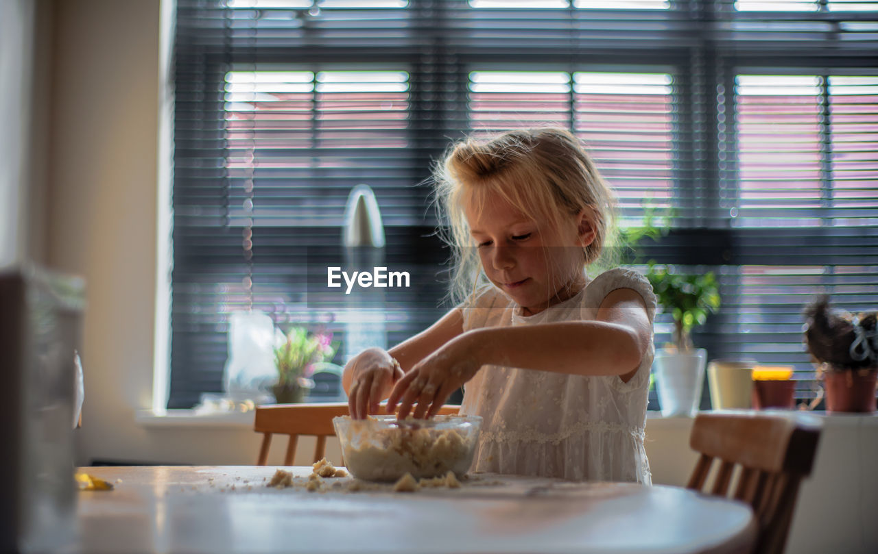 Girl making food on table at home