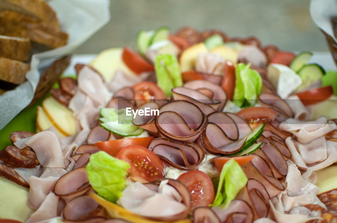 High angle view of chopped vegetables, ham and cheese on table