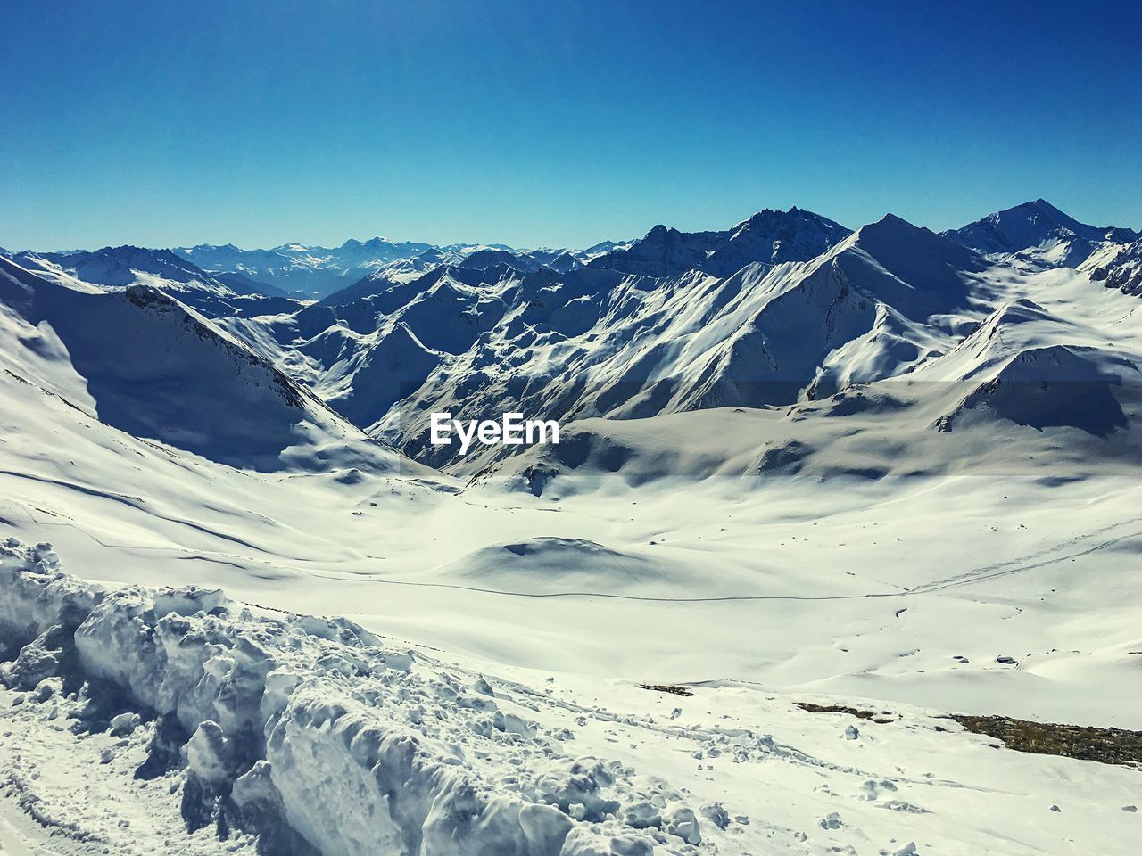 Scenic view of snowcapped mountains against clear blue sky