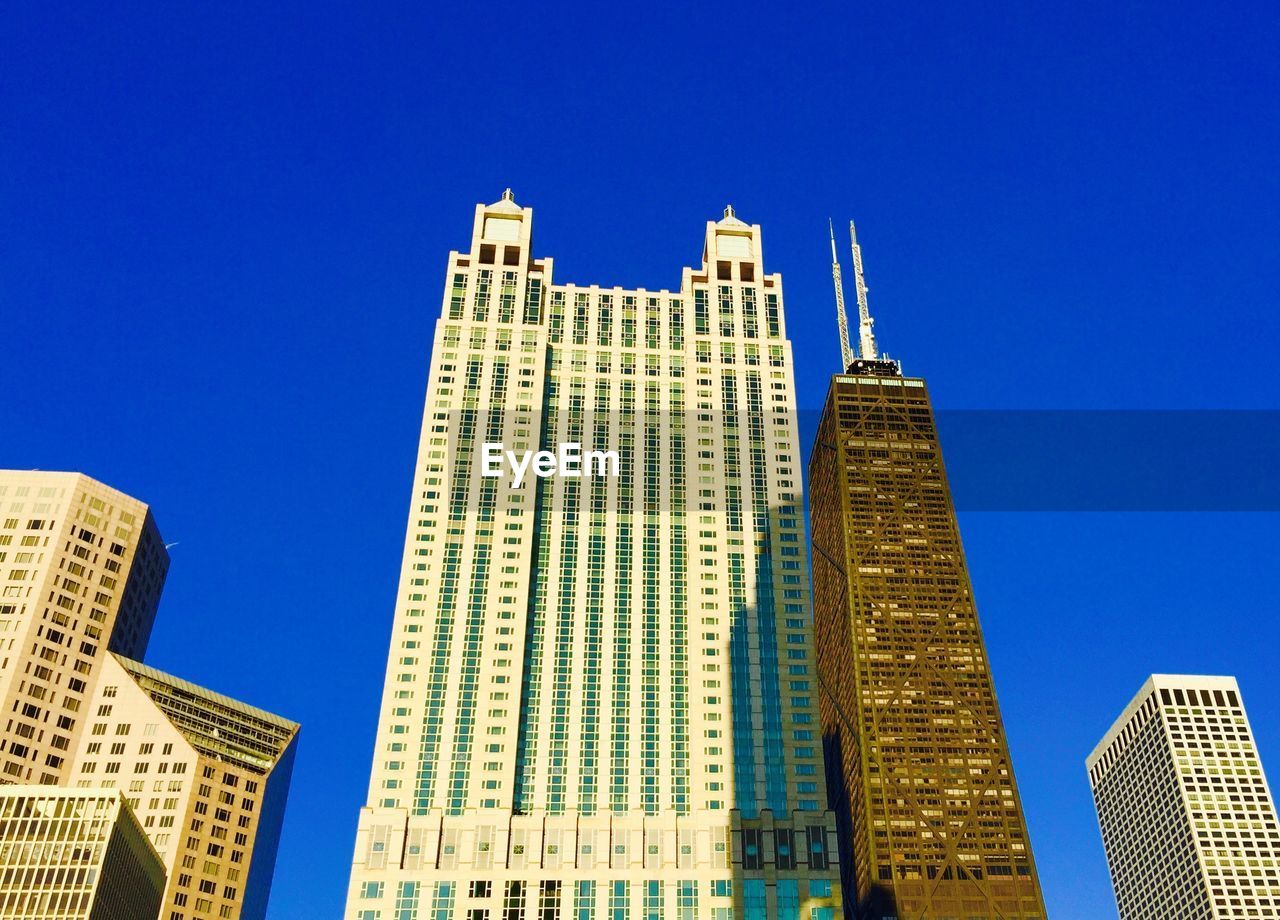 LOW ANGLE VIEW OF SKYSCRAPERS AGAINST CLEAR BLUE SKY
