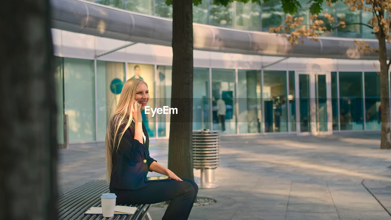 Young woman sitting on chair outdoors