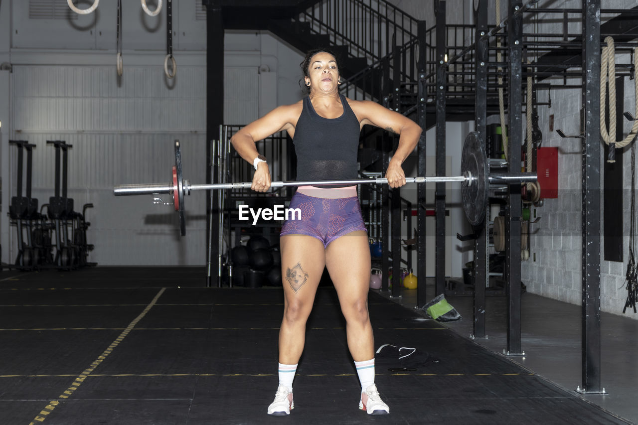 Latin woman lifting weights in a gym