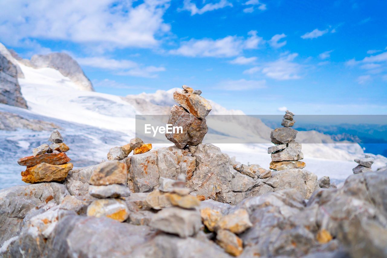 Stack of stones on rocks at mountain against sky