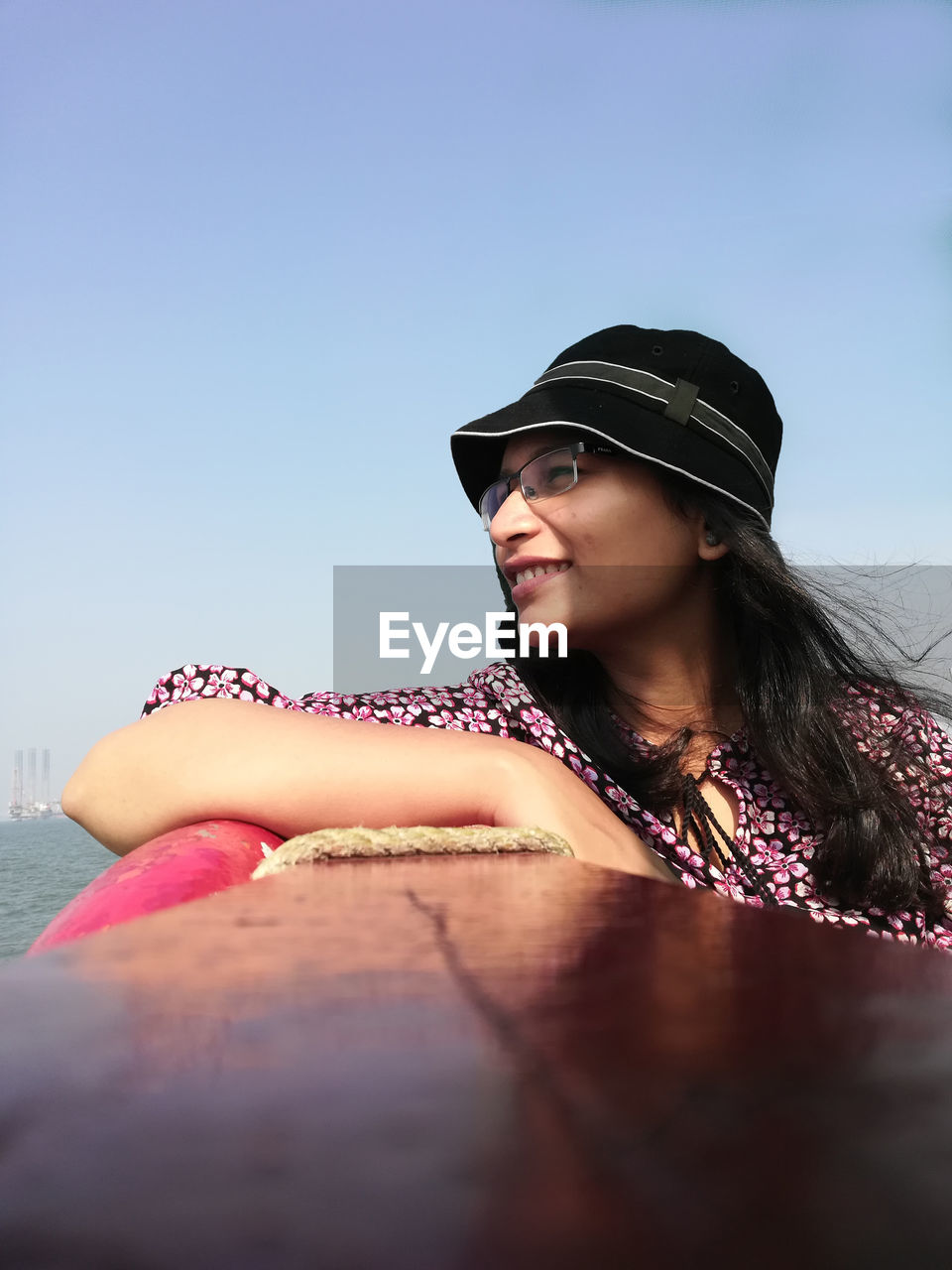 Smiling woman sitting in boat against clear sky