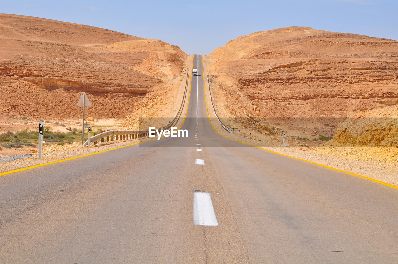 Road amidst field against sky