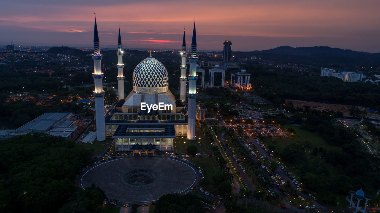 High angle view of city lit up during sunset