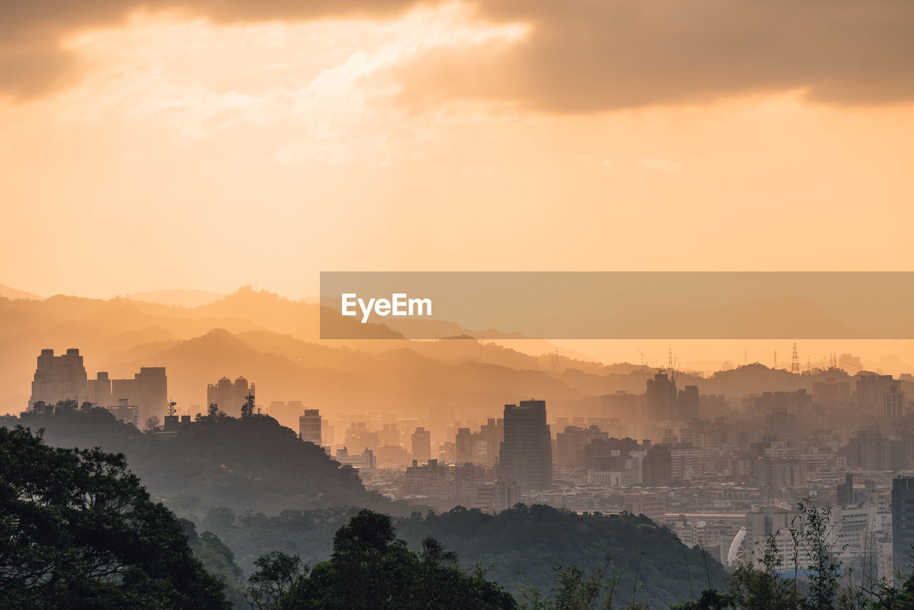 Buildings in city against sky during sunset