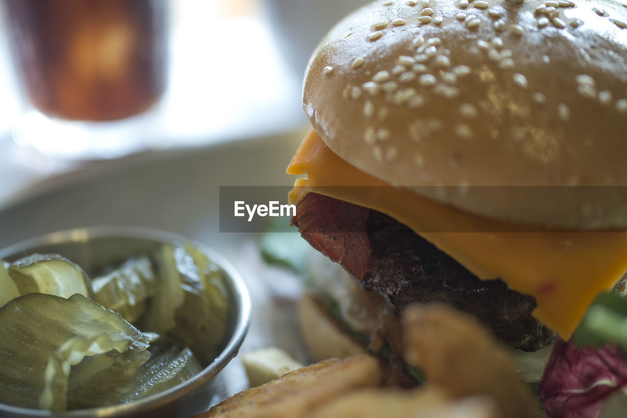 Close-up of burger with pickle on table