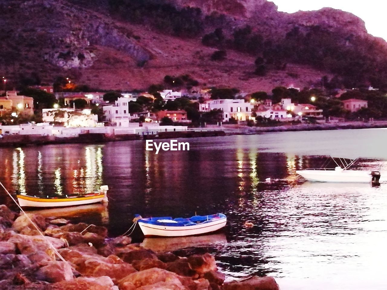 BOATS MOORED AT LAKE AGAINST SKY