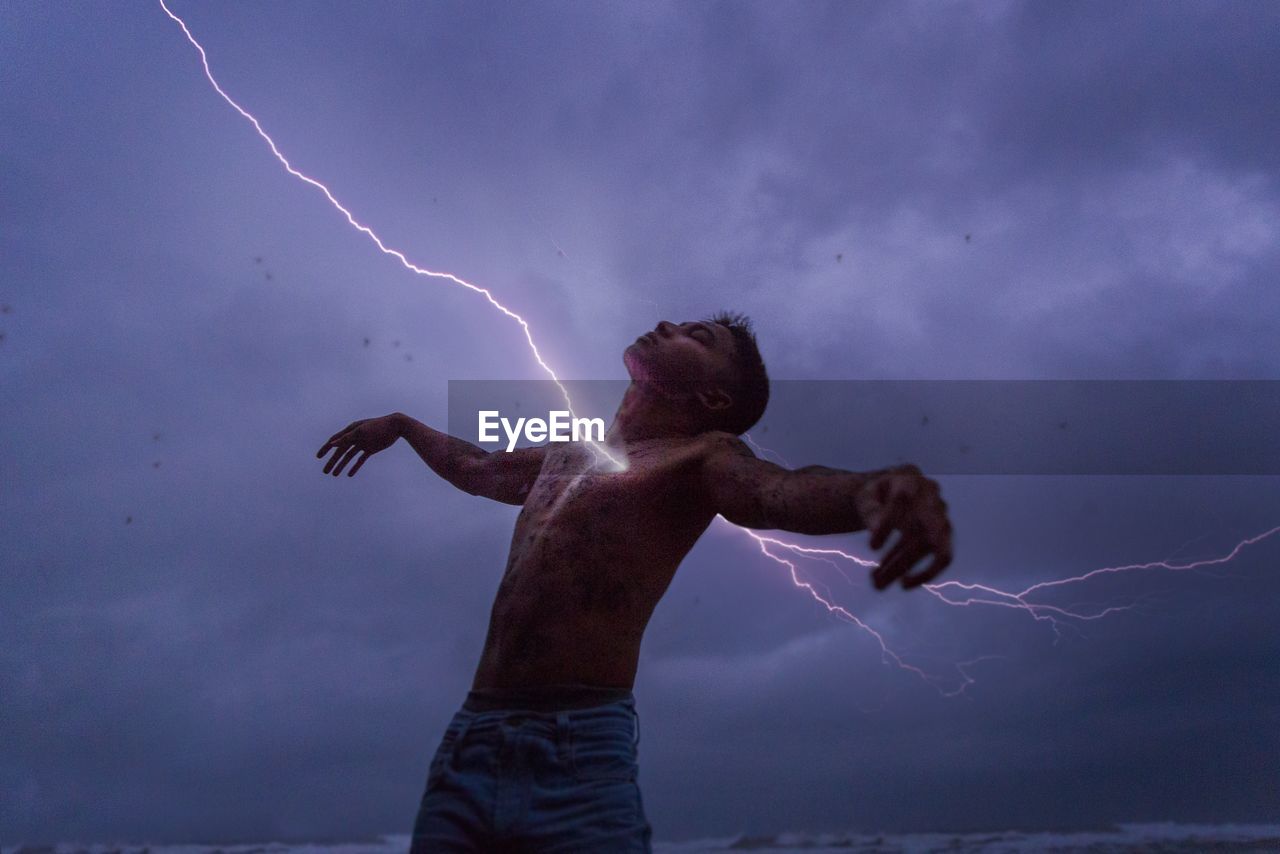 LOW ANGLE VIEW OF MAN STANDING IN SKY