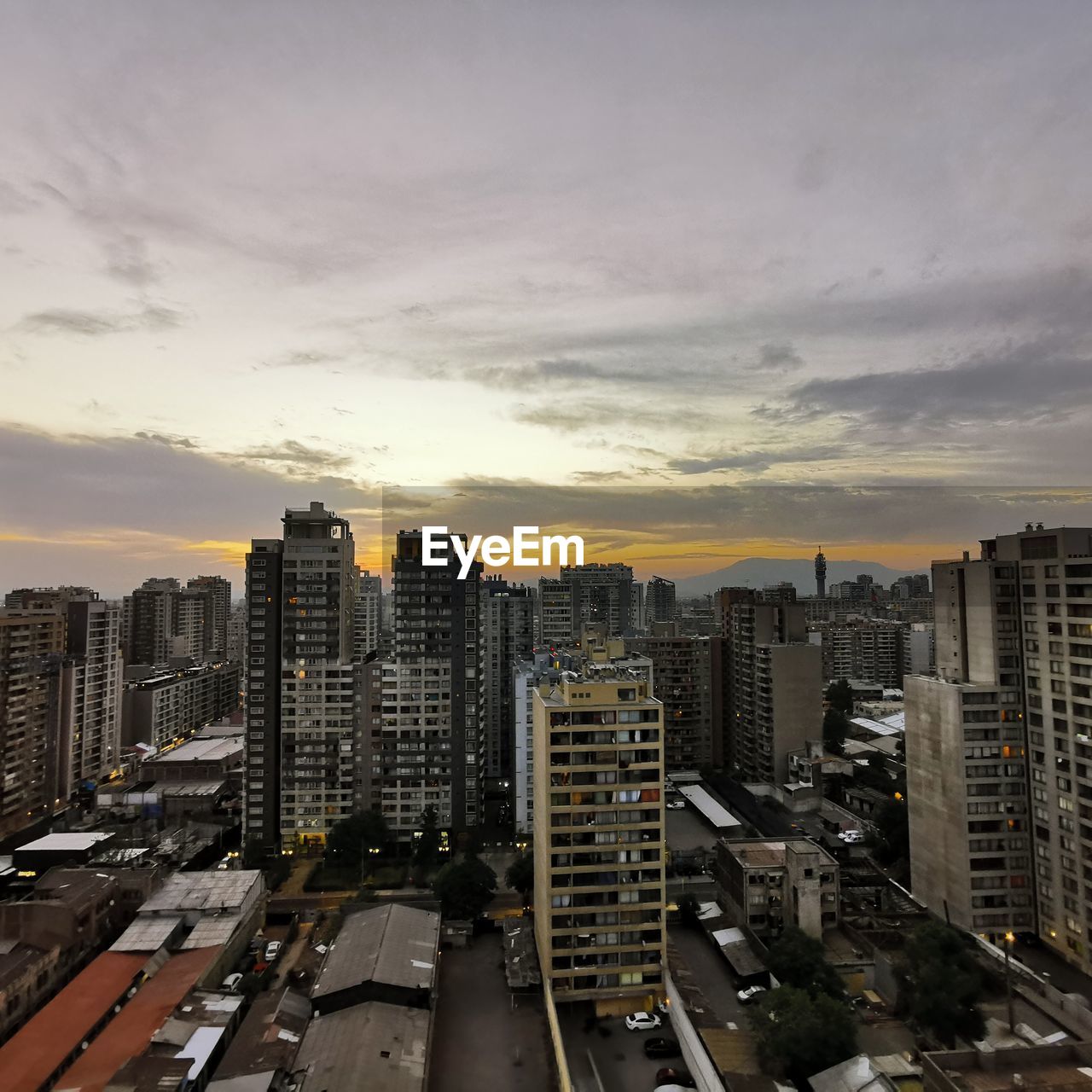 HIGH ANGLE VIEW OF ROAD AMIDST BUILDINGS IN CITY AGAINST SKY