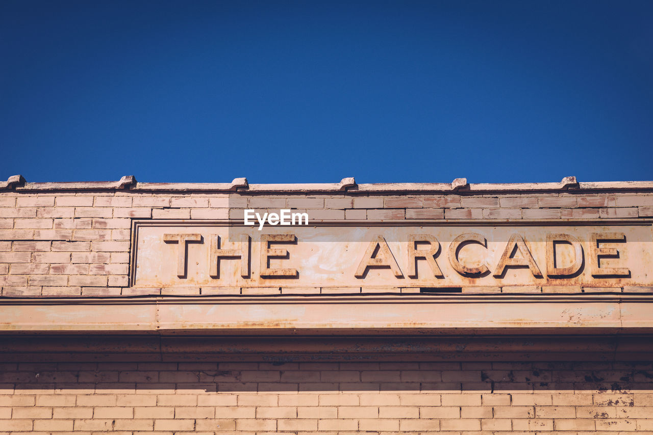 Low angle view of the arcade sign on building against clear sky
