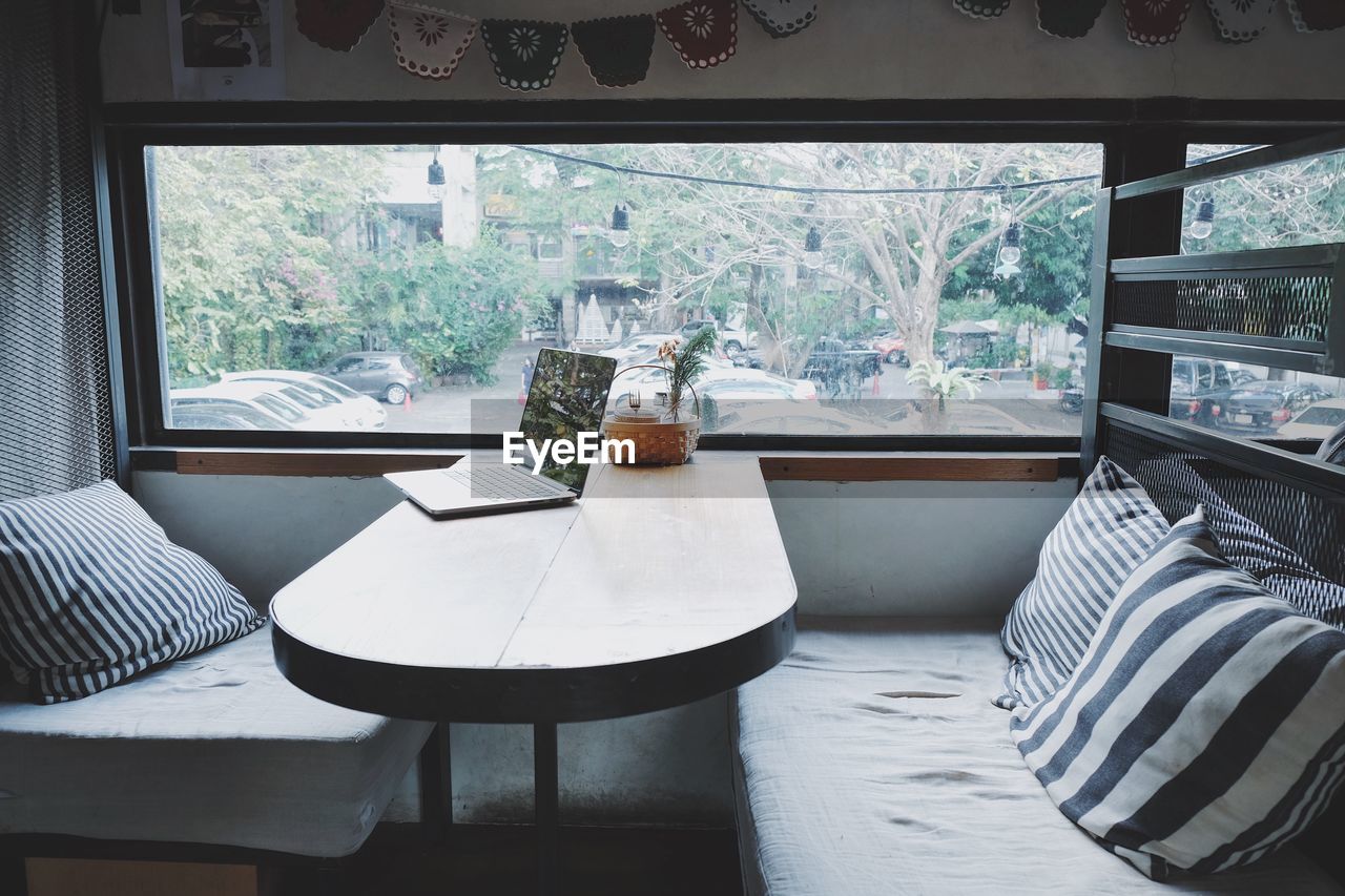 TABLE AND CHAIRS ON BED AGAINST WINDOW