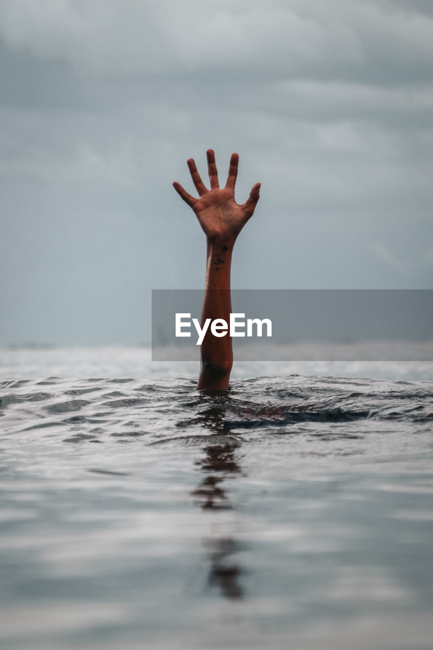 Person swimming in sea against sky