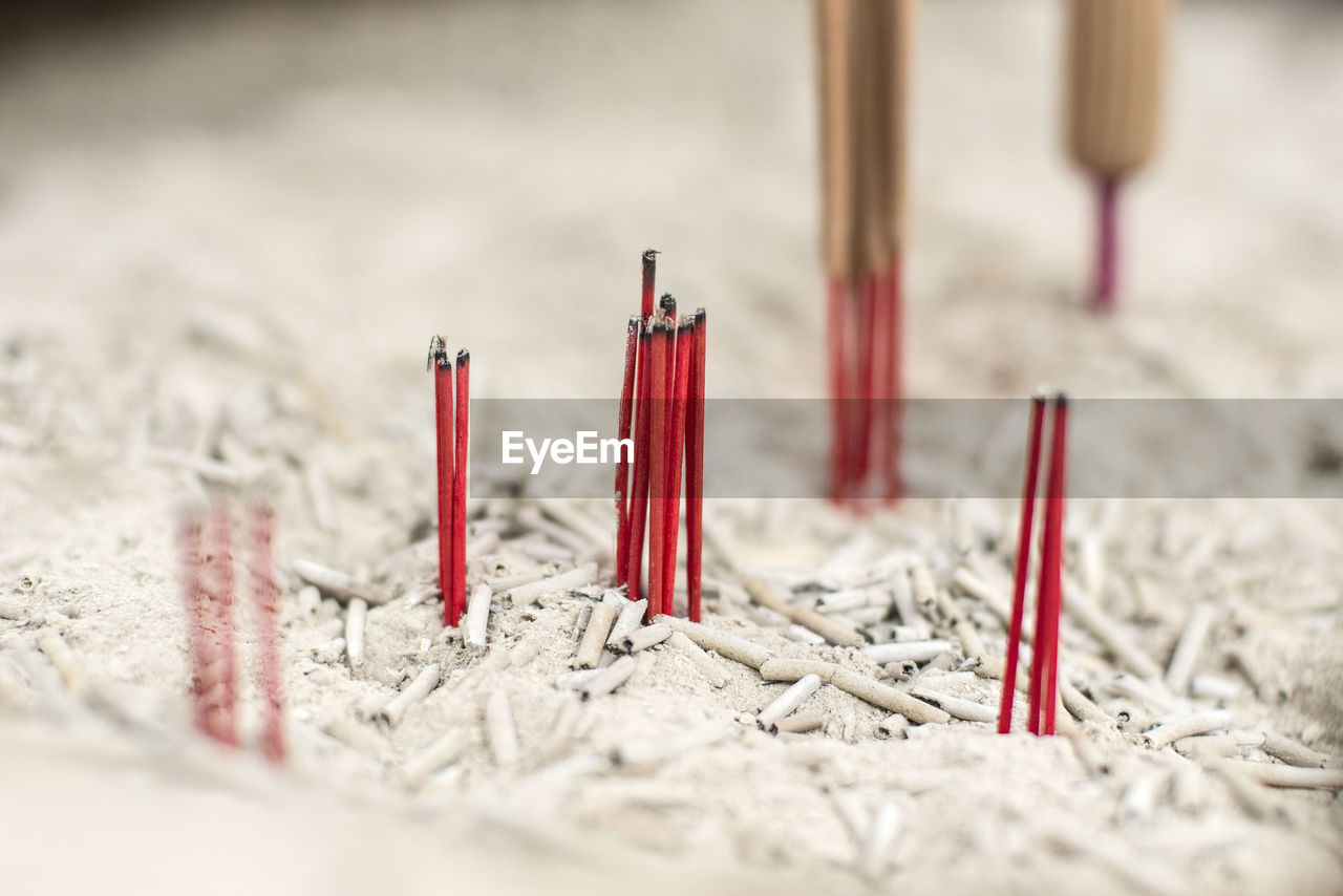 Close-up of burnt joss sticks on sand