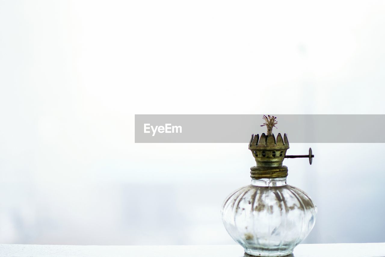 Close-up of antique lamp against white background