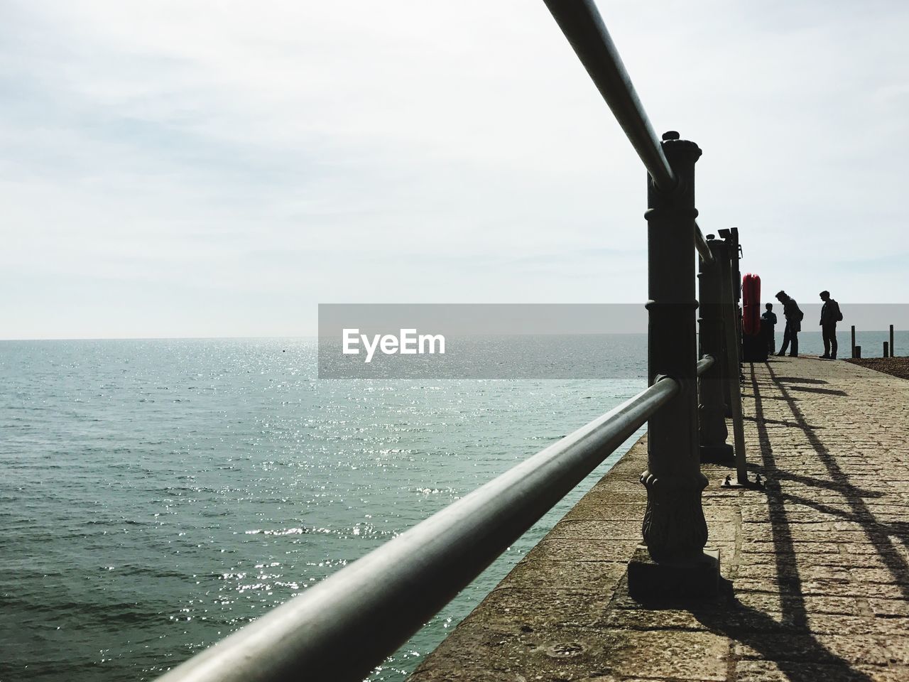 Railing on promenade in sea against sky