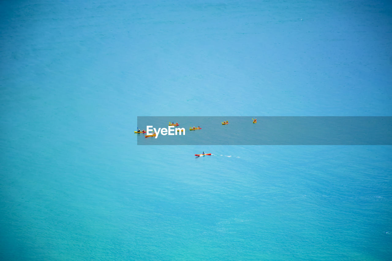 HIGH ANGLE VIEW OF KITE IN SEA AGAINST SKY