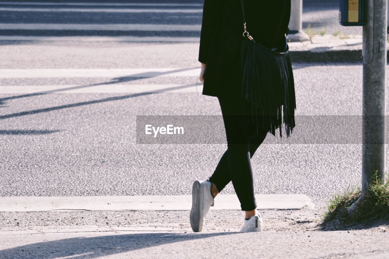 Low section of woman standing on road