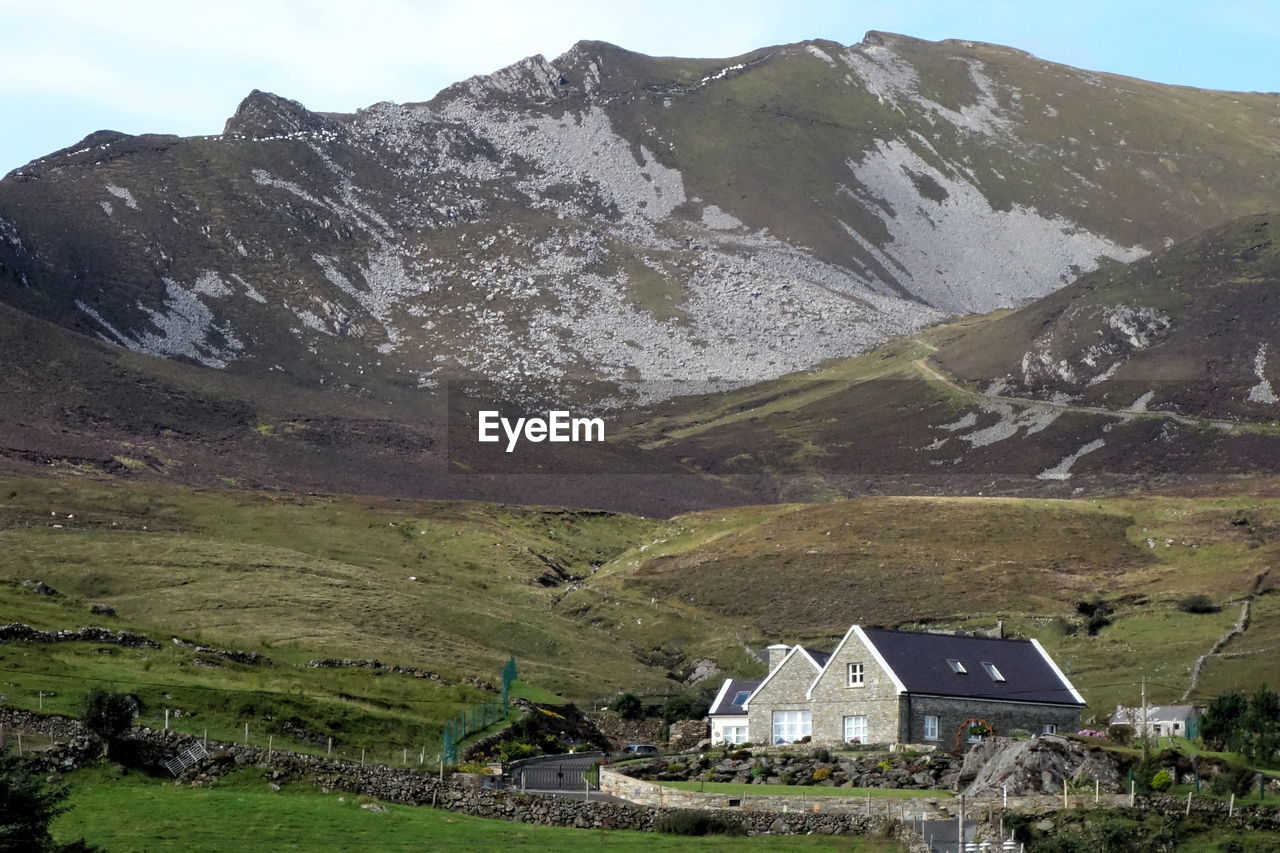 Scenic view of landscape and houses against sky