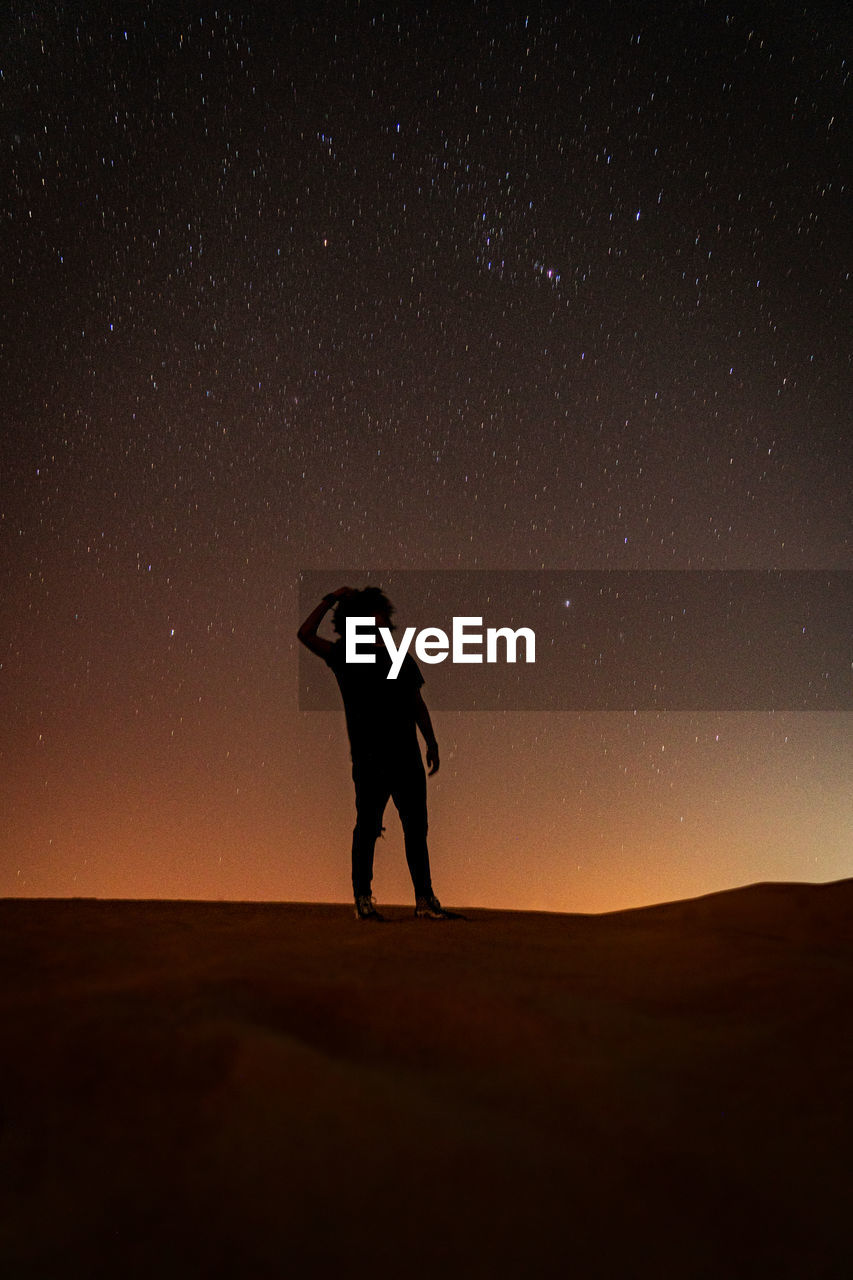 Man staring at the stars in the desert