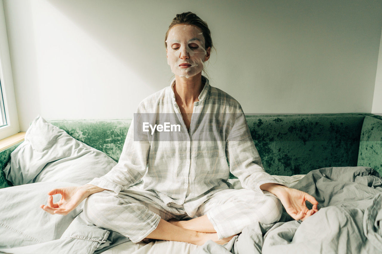 A woman makes a caring beauty procedure at home, a moisturizing cosmetic face mask.
