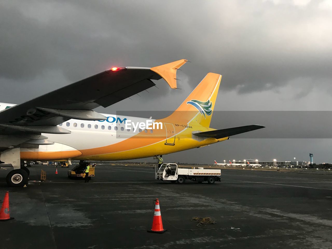 AIRPLANE ON RUNWAY AGAINST SKY AT DUSK