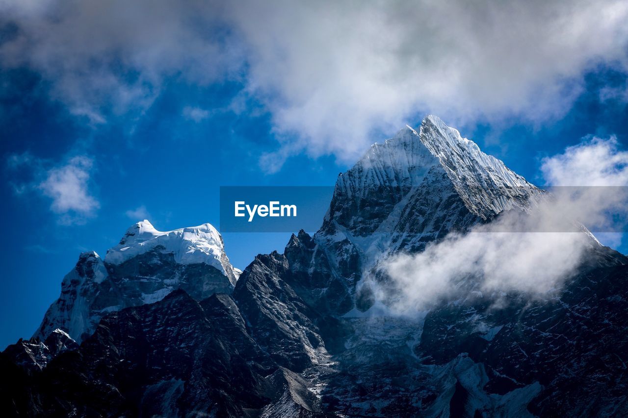 Low angle view of snowcapped mountain against sky