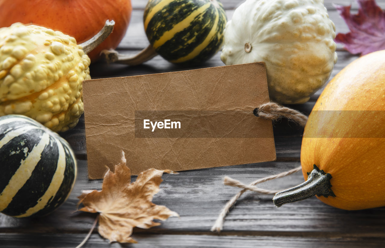 Autumn composition, cozy fall season, pumpkins and leaves on wooden background. 