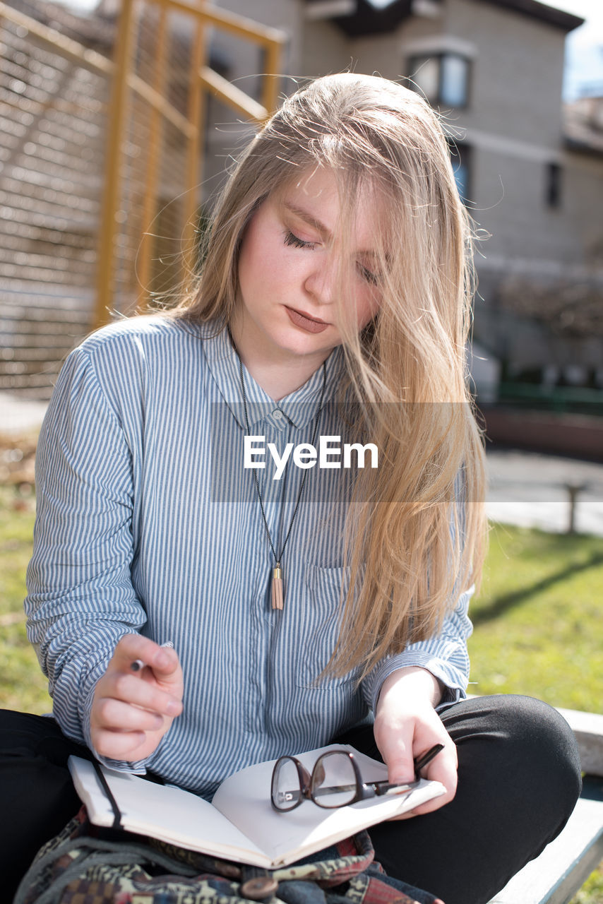 Young woman sitting with notebook