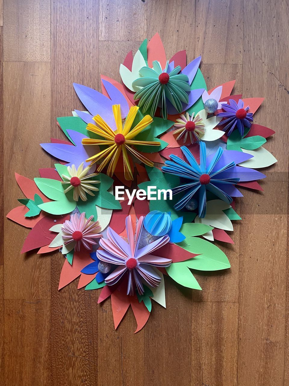 wheel, multi colored, origami, wood, art, creativity, high angle view, paper, no people, art paper, origami paper, craft, indoors, table, directly above, flower, still life, shape, decoration, large group of objects, variation, close-up, petal, blue