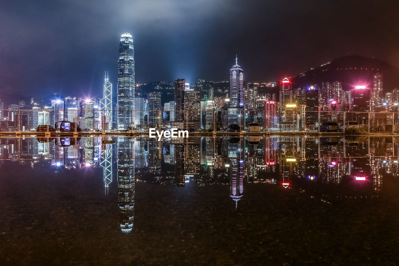 illuminated buildings by river at night