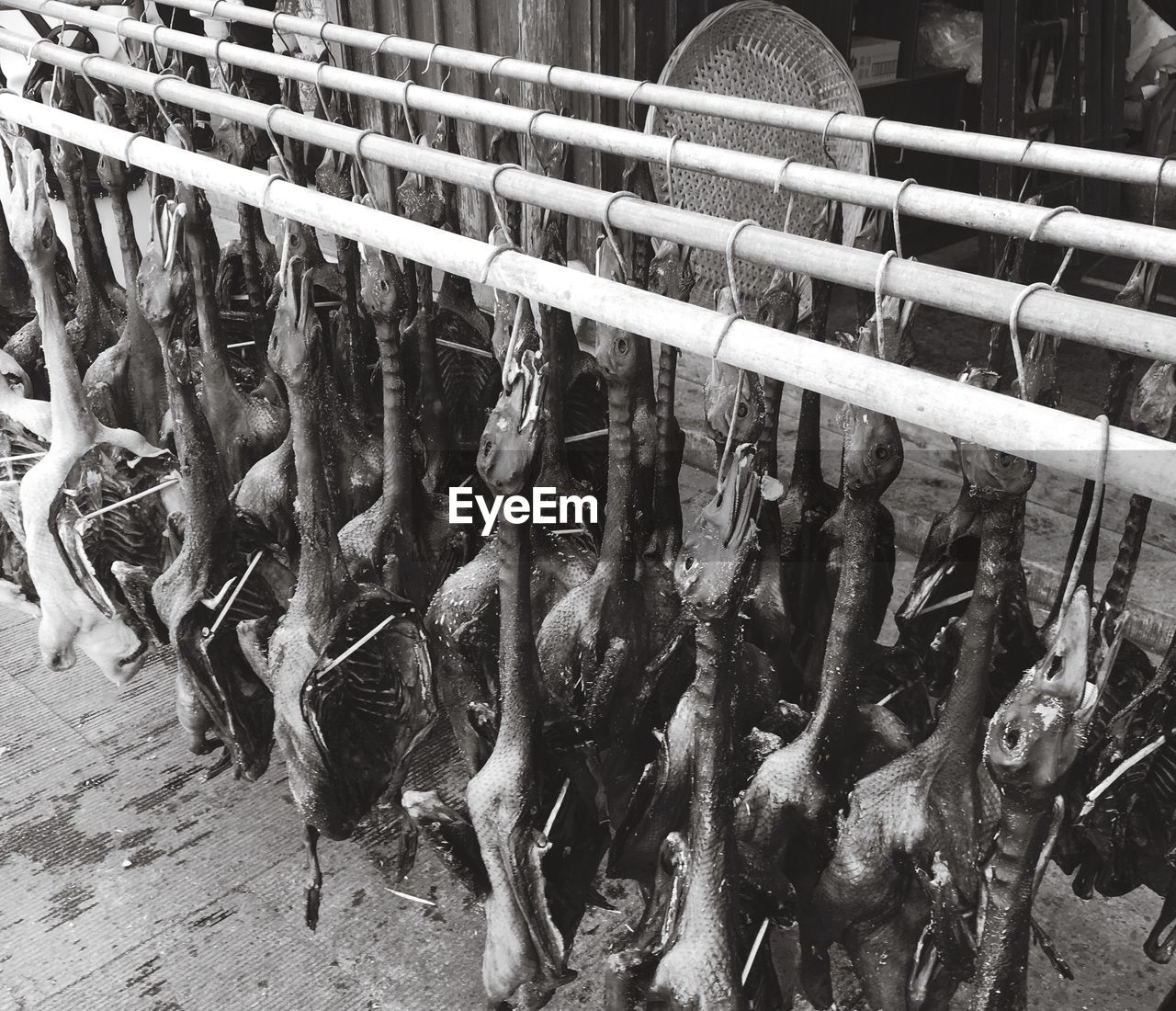 Duck meat hanging from rods for sale at shop