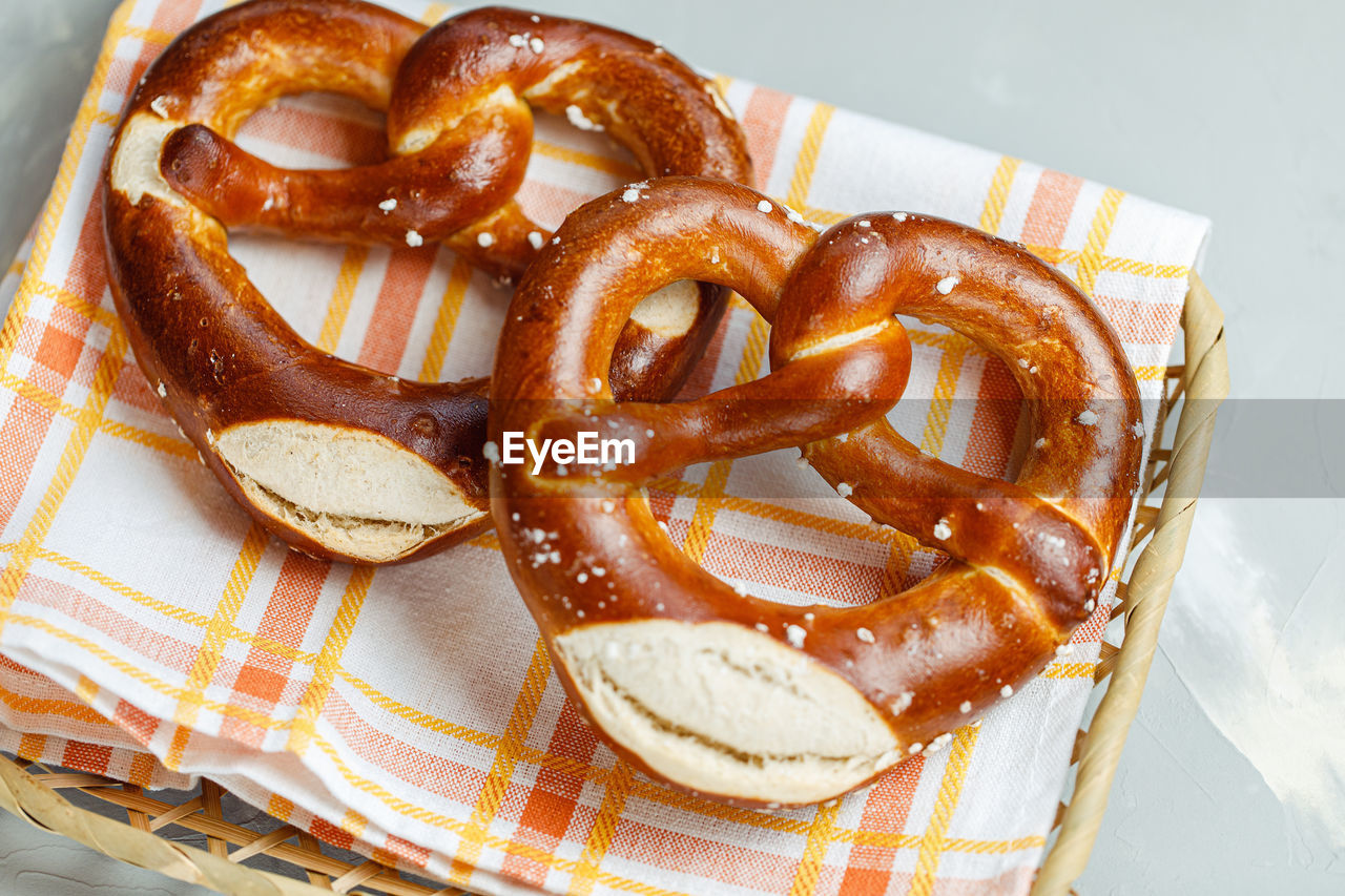 Two traditional soft octoberfest pretzels in bread basket, close-up