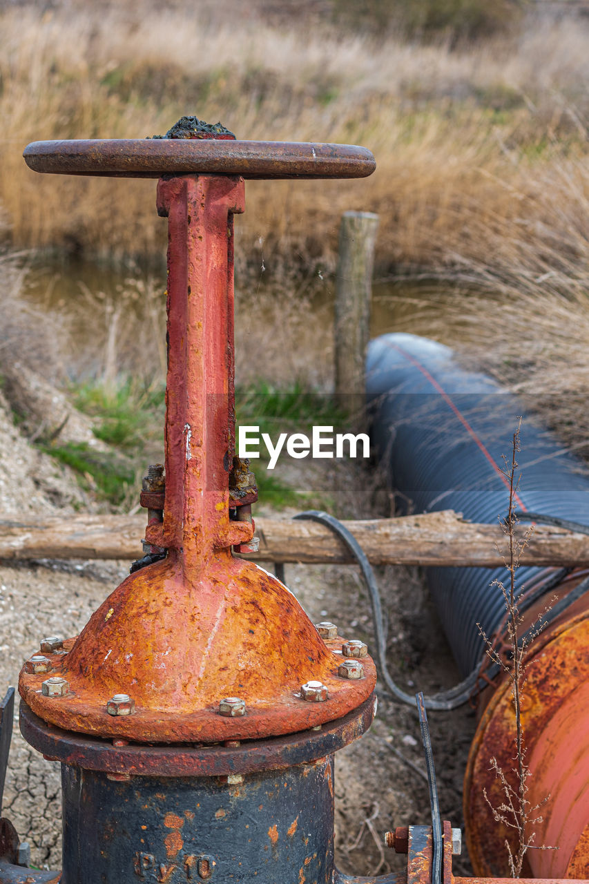 Close-up of rusty metal chain on field