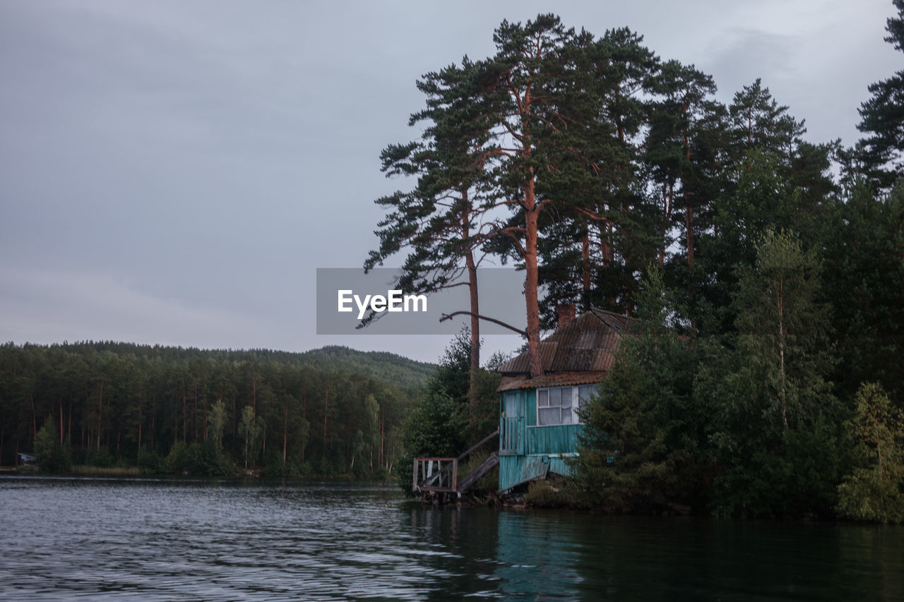 HOUSE BY LAKE AGAINST SKY