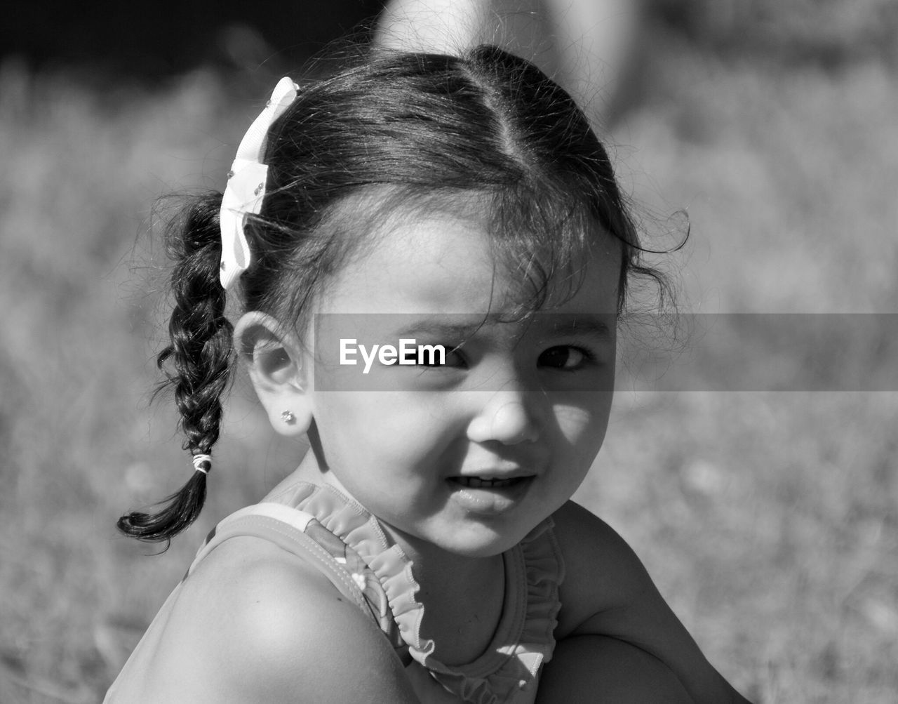 Close-up portrait of girl sitting on field