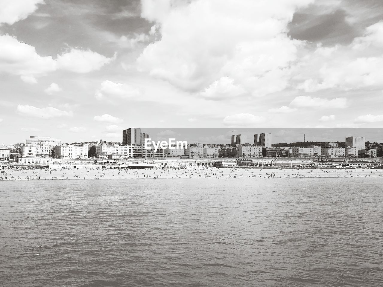 View of cityscape by sea against sky