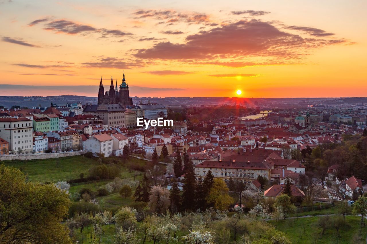 Colorful sunrise view of the city from petrin hill with the castle, garden, trees, river 