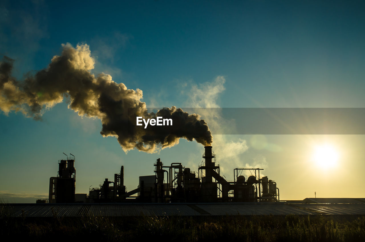 SMOKE EMITTING FROM FACTORY AGAINST SKY AT SUNSET