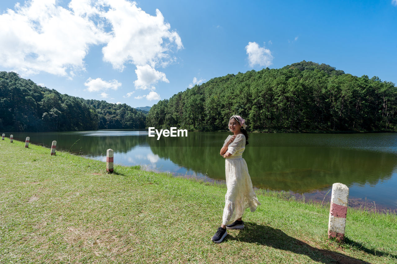 rear view of woman standing on field against sky