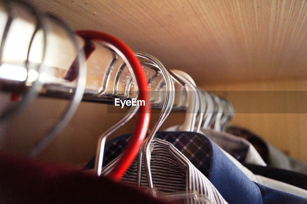 Close-up of shirts hanging on hangers in wardrobe