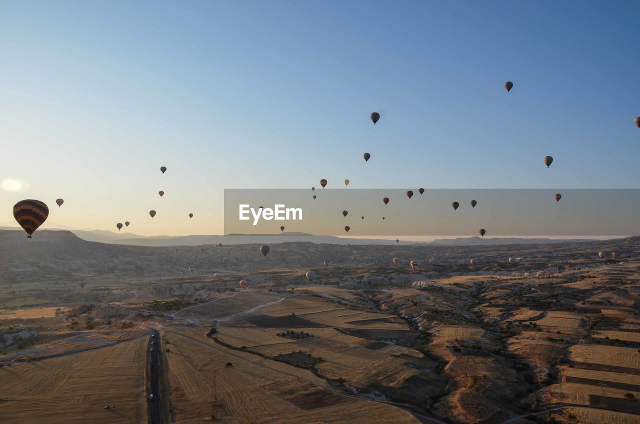 Aerial view of hot air balloons over vast landscape